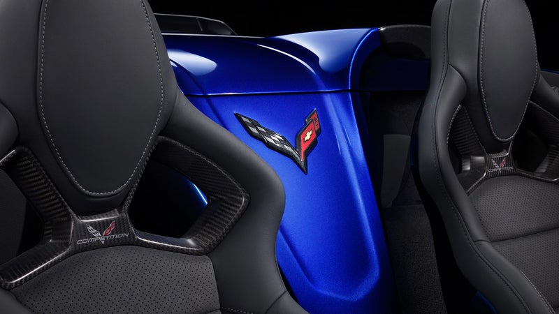 Interior view of a blue Chevy Corvette Z06, showcasing the dashboard and speedometer in a sleek design.