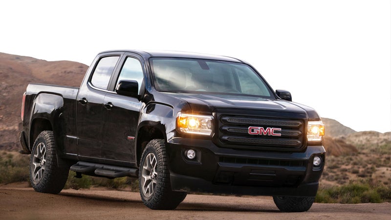 A 2018 GMC Canyon driving along a rugged dirt road