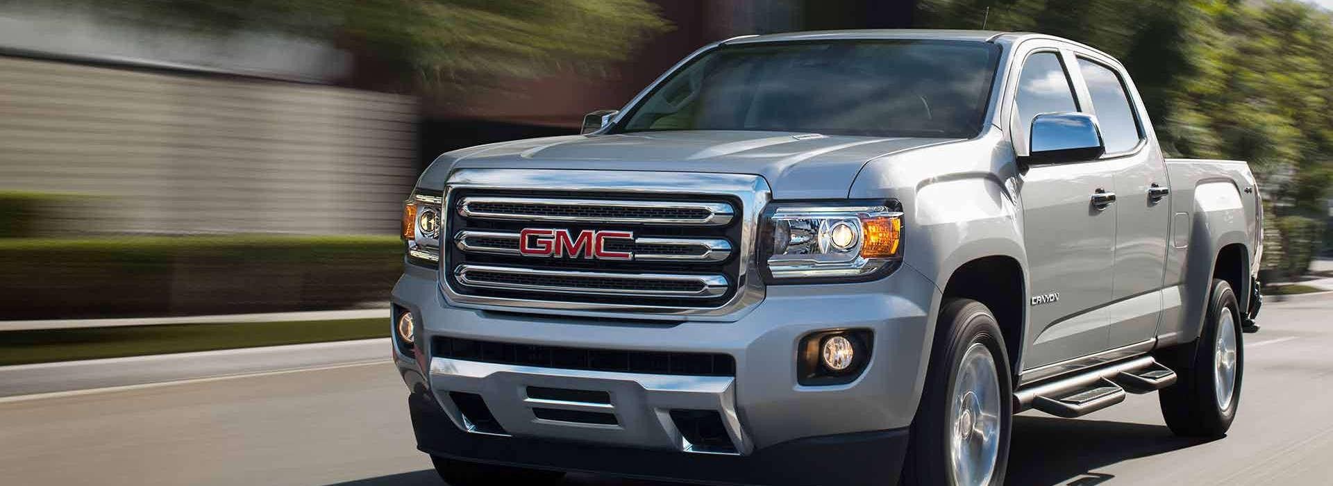 A 2018 GMC Canyon driving along a scenic road
